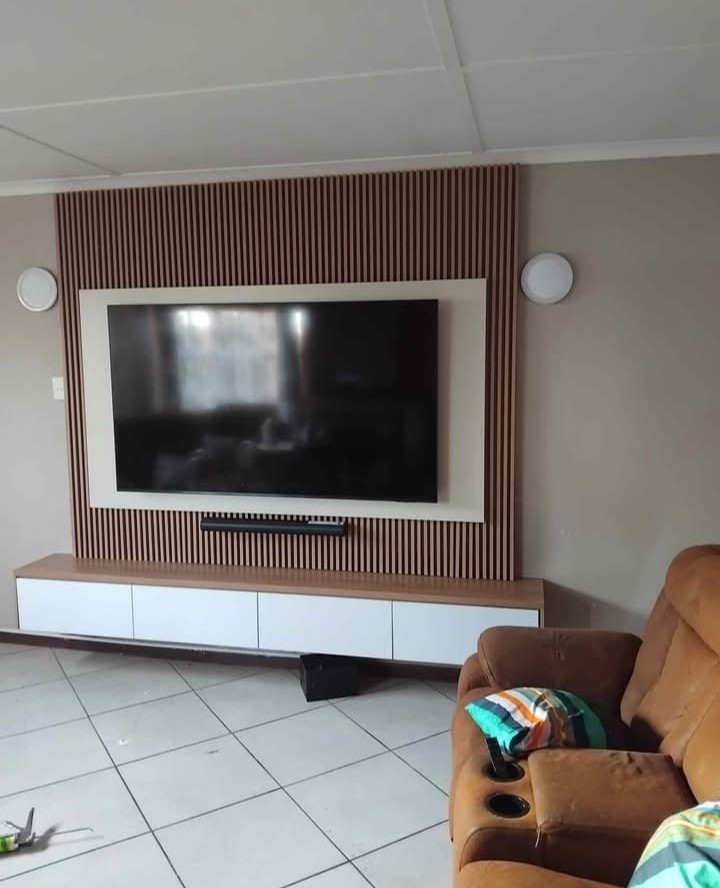Wood slat TV wall with large mounted screen in a lounge