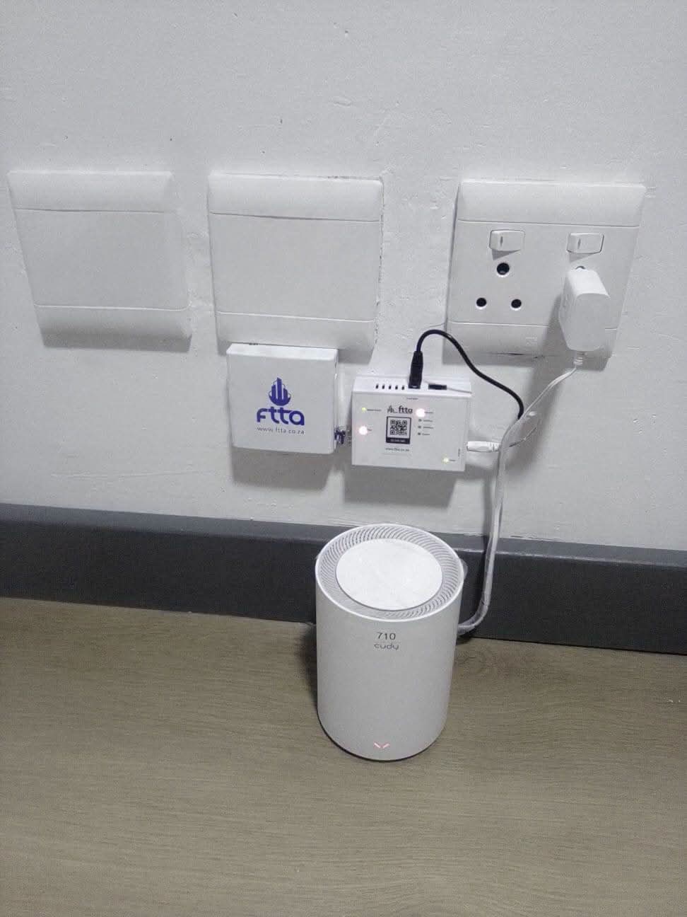 Fibre ONT and WiFi router neatly installed on a wall