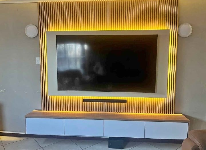 Backlit slatted TV feature wall with mounted TV and soundbar